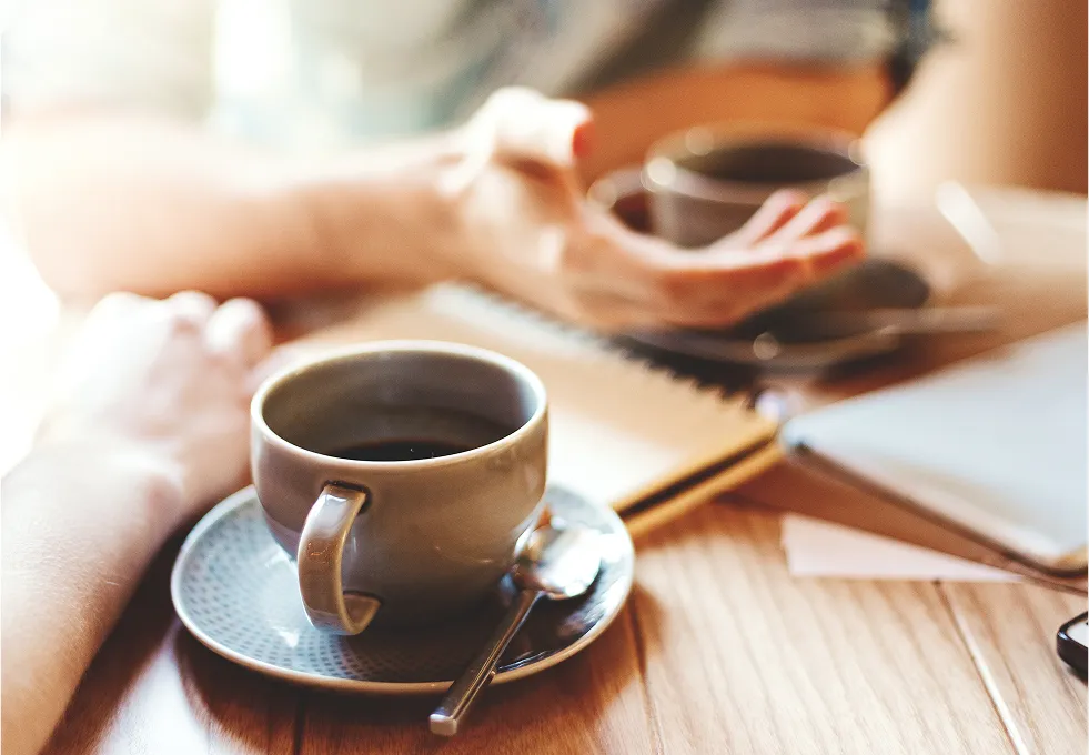 穏やかな光が差し込むカフェのテーブルに置かれたコーヒーカップ。