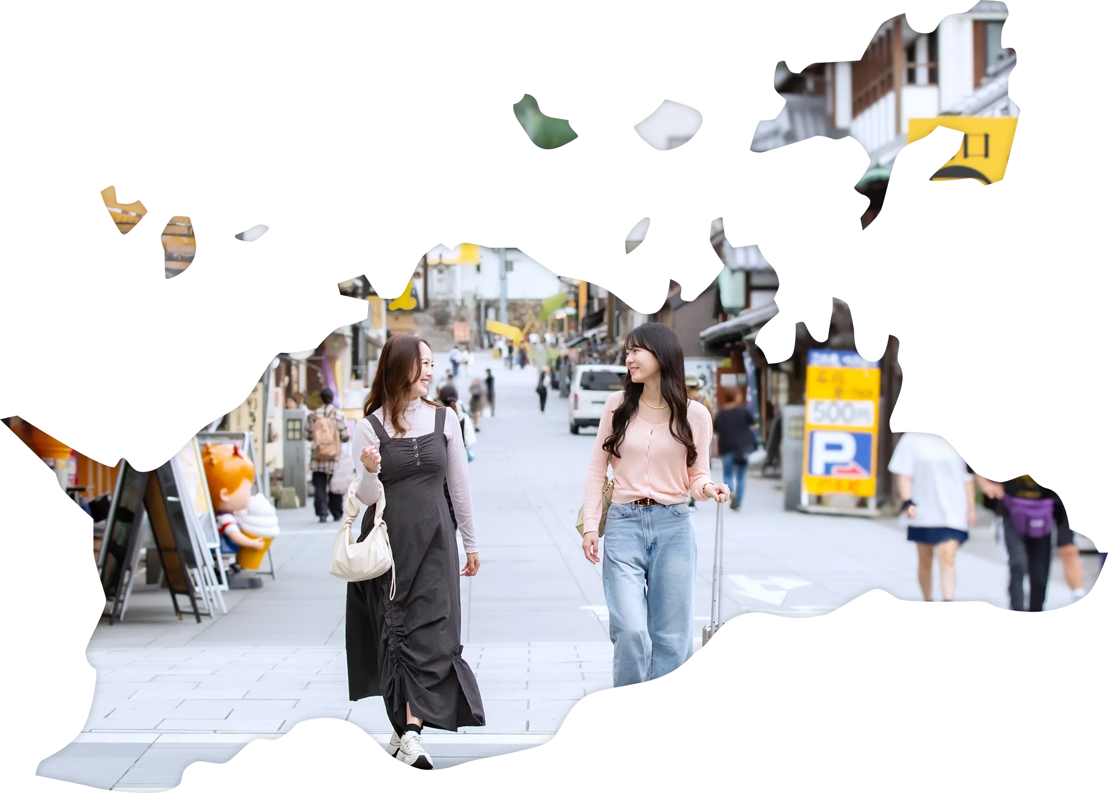 土産物店などが立ち並び、多くの観光客で賑わう参道を、楽しそうに歩く二人の女性。