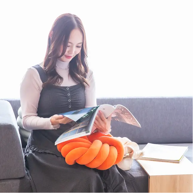 ソファで雑誌を読む女性の画像。