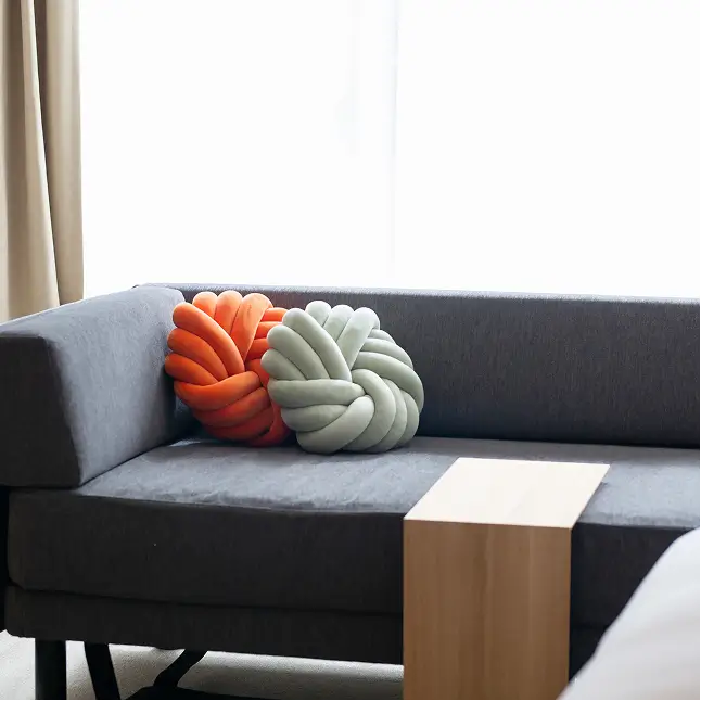 ソファにツイスト状のクッションが置いてあります。