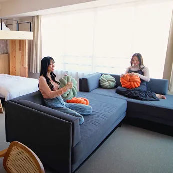 ソファ上で寛ぐ二人の女性。