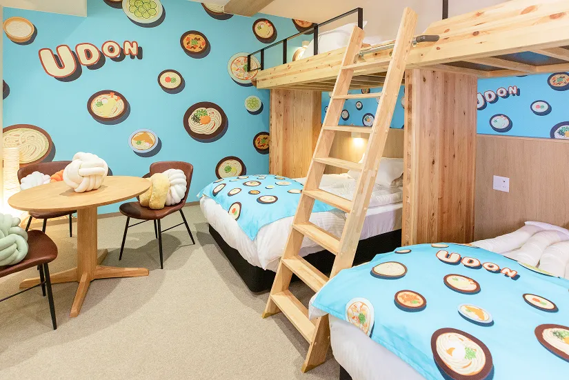 「UDONコンセプトルーム」ポップな壁紙が貼られた客室。