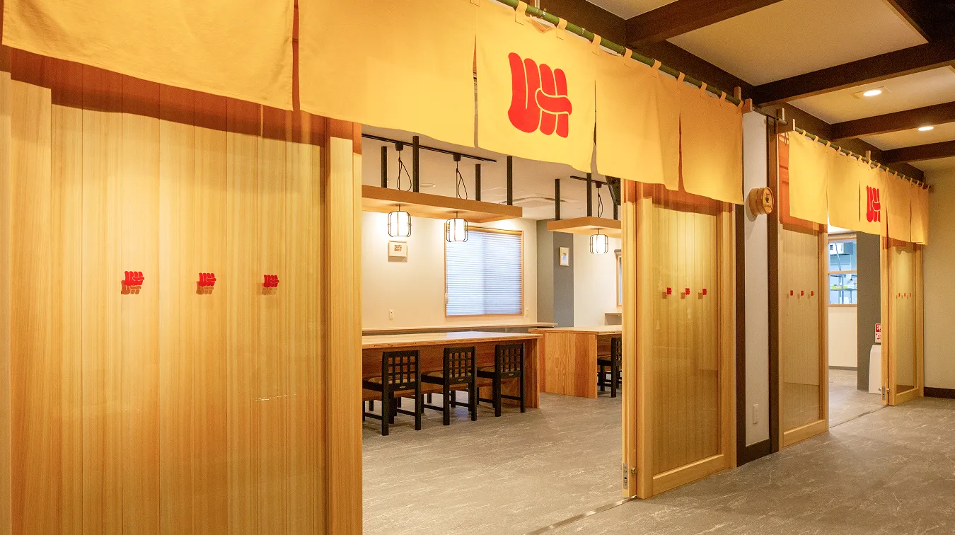 黄色いのれんが特徴なうどんバルの入り口。